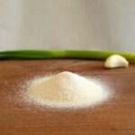 Vitlökssalt på träbrun skärbräda